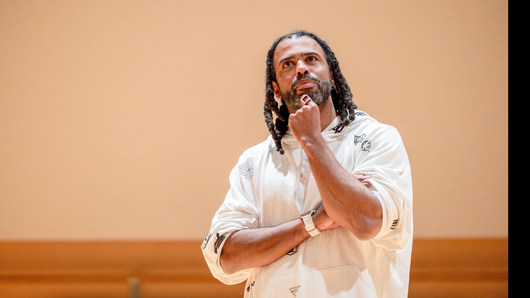 Daveed Diggs stands with a hand on his chin in the Class of ’56 Dance Studio Theatre.